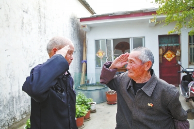 對(duì)話(huà)入朝作戰(zhàn)河南老兵 吃土豆喝鹽水，雪地里趴?jī)商煲灰? /></p>
<p>老兵鄒玉振(左）和袁國(guó)章（右）兩名同上過(guò)朝鮮戰(zhàn)場(chǎng)的老兵70年后相見(jiàn)互敬軍禮</p>
<p>□頂端新聞·大河報(bào)記者 朱長(zhǎng)振 文圖</p>
<p>沒(méi)有國(guó)，哪有家？今年是中國(guó)人民志愿軍抗美援朝出國(guó)作戰(zhàn)71周年，伴隨著電影《長(zhǎng)津湖》在國(guó)慶期間的熱映，記者再次把鏡頭對(duì)準(zhǔn)這群“最可愛(ài)的人”。</p>
<p>駐馬店兩位老兵鄒玉振、袁國(guó)章回國(guó)退伍后各自忙于各自的生活，如今生活平靜。2020年，記者就曾去采訪(fǎng)過(guò)兩位老兵，兩家相距不遠(yuǎn)，他們不在同一個(gè)部隊(duì)，沒(méi)有一起打過(guò)仗，碰了面卻用朝鮮語(yǔ)對(duì)起話(huà)來(lái)。說(shuō)著說(shuō)著，兩位老兵的眼眶濕潤(rùn)了，互相擁抱著，久久不愿分開(kāi)。今年隨著《長(zhǎng)津湖》的熱映，記者再次與老兵們聊起了戰(zhàn)斗歲月，電影里面美軍飛機(jī)讓志愿軍吃了不少苦頭，老兵們作為機(jī)炮連戰(zhàn)士，他們經(jīng)歷的戰(zhàn)場(chǎng)到底是什么樣的？</p>
<p>對(duì)話(huà)老兵</p>
<p>凍土豆用牙刮著吃</p>
<p>記者：你在朝鮮戰(zhàn)場(chǎng)上吃過(guò)土豆沒(méi)有？鄒玉振：吃過(guò)，吃土豆喝鹽水。那時(shí)候咱們國(guó)家窮，在戰(zhàn)場(chǎng)上不能像美國(guó)兵那樣吃細(xì)米白面，還有啤酒、咖啡喝，戰(zhàn)爭(zhēng)結(jié)束后回到國(guó)內(nèi)才能吃飽肚子。袁國(guó)章：吃過(guò)，（吃的時(shí)候得）再熱熱，糧食送不過(guò)去，凍土豆啃也啃不動(dòng)，用牙刮著吃，渴了，抓一把雪填嘴里。記者：在雪地里埋伏過(guò)沒(méi)有？鄒玉振：在雪地里趴過(guò)兩天一夜，身體弱的凍死了，身體好的熬過(guò)來(lái)了。有凍傷的，有的人腳指頭都截了，有的腿都截了。袁國(guó)章：經(jīng)常在雪地里趴著，趴那里也不動(dòng)，經(jīng)常在戰(zhàn)壕里一趴就是一天一夜，（打仗）誰(shuí)敢動(dòng)一下？記者：打落過(guò)美軍敵機(jī)沒(méi)？鄒玉振：打落過(guò)不少，在清川江大橋，打落過(guò)敵人的飛機(jī)，高炮也多，高射機(jī)槍也多。我們當(dāng)時(shí)有20個(gè)高炮團(tuán)，100個(gè)高炮營(yíng)。袁國(guó)章：我的部隊(duì)打過(guò)，打過(guò)飛機(jī)，也用炮打下來(lái)過(guò)一架。</p>
<p>老兵口述</p>
<p>鄒玉振：指揮戰(zhàn)士打落美軍飛機(jī)</p>
<p>我從小命苦，十幾歲的時(shí)候參加國(guó)軍，開(kāi)始和日本鬼子打。日本鬼子投降之后，我投誠(chéng)當(dāng)了八路。</p>
<p>在1949年的時(shí)候，我跟著部隊(duì)一路南下，得到消息朝鮮戰(zhàn)爭(zhēng)打起來(lái)了。其間我們?cè)趶V播上多次聽(tīng)上級(jí)說(shuō)，美國(guó)雖然在打朝鮮，但是緊挨著朝鮮的就是我們中國(guó)，我們國(guó)家經(jīng)不起折騰了，必須去支援朝鮮！</p>
<p>我們?nèi)氤鲬?zhàn)后，我當(dāng)時(shí)所屬的部隊(duì)是某軍三十二師九十五團(tuán)一營(yíng)機(jī)炮連，負(fù)責(zé)防空，主要對(duì)付美國(guó)人的飛機(jī)。再后來(lái)我的部隊(duì)去守下惠山打了一天一夜，戰(zhàn)斗極為慘烈，我們的排長(zhǎng)受傷了，臨時(shí)讓我頂替排長(zhǎng)的位置。</p>
<p>當(dāng)我當(dāng)上排長(zhǎng)那一刻，我深感自己的責(zé)任重大，這個(gè)時(shí)候西南方向飛過(guò)來(lái)了美國(guó)兵的戰(zhàn)斗機(jī)。我來(lái)不及學(xué)習(xí)，趕緊指揮。按照以前我的排長(zhǎng)的指揮方式，對(duì)著對(duì)講機(jī)喊道“西南五百，高度八百，放！”然后炮彈“嘟”“嘟”“嘟”“嘟”地發(fā)射了出去，目睹著這架飛機(jī)被打落，心中滿(mǎn)滿(mǎn)的成就感，當(dāng)時(shí)激動(dòng)得我全身都在顫抖。</p>
<p>1953年，我們突然接到命令，要去守清川江大橋了。我的部隊(duì)都是高射機(jī)槍?zhuān)艟嚯x6里地，主要負(fù)責(zé)保護(hù)高射炮。在清川江大橋邊上，我們打了7天7夜，打著打著，停戰(zhàn)了，我們下了汽車(chē)換乘火車(chē)，去了師指揮所，守了兩年的師指揮所。</p>
<p>雖然我是代理排長(zhǎng)，但是把我的兵管理得還算可以，起碼沒(méi)有出意外，領(lǐng)導(dǎo)就任命我為排長(zhǎng)了。</p>
<p>袁國(guó)章：長(zhǎng)相秀氣的老鄉(xiāng)戰(zhàn)友在眼前犧牲</p>
<p>我被分配在某軍186師557團(tuán)2營(yíng)機(jī)炮連，到1950年的時(shí)候，我成為了文化教員。</p>
<p>我們根據(jù)當(dāng)時(shí)的情況，編了一些順口溜：“小鬼子，美國(guó)兵，有三怕，一怕打野戰(zhàn)，二怕拼刺刀，三怕手榴彈把他崩！”這個(gè)順口溜編完，我們都笑。笑著笑著，周?chē)膽?zhàn)士們眼角都濕潤(rùn)了。美國(guó)兵為啥會(huì)有這三怕，這是我們的戰(zhàn)士擅長(zhǎng)的，硬生生給他們打怕的。論裝備，美國(guó)兵比我們精良；論條件，美國(guó)兵比我們好太多了。但是我們不能怕啊，我們不能退，我們的背后，就是我們的國(guó)家，我們的親人！</p>
<p>我有個(gè)關(guān)系特別好的戰(zhàn)士兄弟，他叫侯順章，也是我們河南的老鄉(xiāng)，長(zhǎng)得很秀氣，放在現(xiàn)在，他絕對(duì)是個(gè)大帥哥。那天我們正在山溝里休息，美國(guó)的飛機(jī)飛過(guò)來(lái)了，飛機(jī)下方緊跟著美國(guó)兵。侯順章不知道怎么回事，莫名其妙地給我說(shuō)槍聲很好聽(tīng)，他聽(tīng)愣神了，竟然站了起來(lái)，不幸被敵人擊中犧牲。那場(chǎng)戰(zhàn)斗很慘烈，當(dāng)戰(zhàn)斗結(jié)束的時(shí)候，我爬著后撤，邊爬邊拉著他往后走。等確定安全的時(shí)候，我忍不住地流下了眼淚，就地挖個(gè)坑給他埋了。沒(méi)有墓碑，我只給他插了個(gè)樹(shù)枝當(dāng)他的墓碑，然后匆匆撤退。我一直到下了戰(zhàn)場(chǎng)，也沒(méi)有機(jī)會(huì)去給他掃掃墓，我甚至都忘了我把他埋在哪里了。</p>
<p>1952年開(kāi)始，戰(zhàn)爭(zhēng)沒(méi)有那么激烈了，但是前線(xiàn)的小摩擦還是不斷，聽(tīng)說(shuō)中國(guó)一直在和美國(guó)談，一直到1953年，我們才開(kāi)始撤軍。</p>
      <!--ecms.*-->
      <p class=